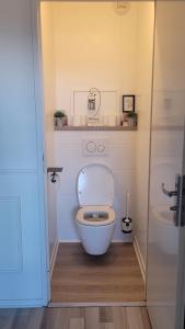 - une salle de bains avec des toilettes blanches dans une cabine dans l'établissement Cosy Home Paris, à Carrières-sous-Poissy