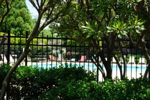 una piscina detrás de una valla con sillas y árboles en Lovely townhouse, en Charlotte