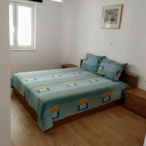 una camera da letto con un letto con lenzuola blu e una finestra di Teta Lidia a Krilo