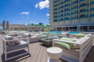 a patio with several beds and tables and a building at Ocean views Walk to beach Waikiki and mall 1223 in Honolulu