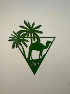un emblema verde con un camello y palmeras en Skylen Apartment 2 en Hurghada
