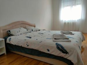 a bedroom with a bed with a blanket and a window at Apartman Aleksandar in Zvornik