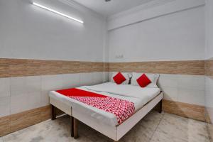 Un dormitorio con una cama con almohadas rojas. en OYO Flagship Goodwill Lodging, en Bombay