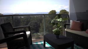 balcón con sillas, mesa y ventana grande en Port Aventura 5 min à pied - Superbe appartement, en Salou