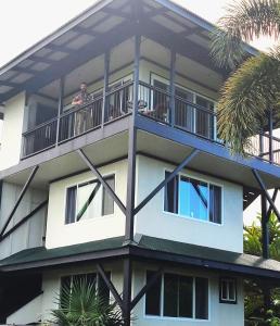 a man standing on the balcony of a building at Island Goode's - Luxury Adult Only Accommodation near Hilo in Papaikou