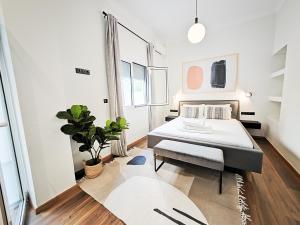 - une chambre avec un lit et une plante en pot dans l'établissement SAV12 Family Apartment Patisia Athens, à Athènes