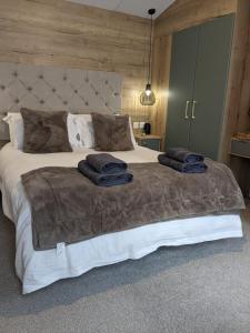 ein Schlafzimmer mit einem großen Bett mit zwei Handtüchern darauf in der Unterkunft Waterfoot Lodge in Little Habton