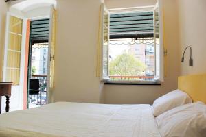 1 dormitorio con cama blanca y ventana en Affittacamere Delaide, en Levanto
