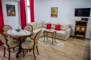 a living room with a couch and a table and chairs at Apartman Centar in Sremski Karlovci