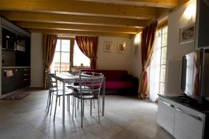 un salon avec une table, des chaises et un canapé dans l'établissement Casa Marizzoni, à Peio Fonti