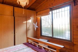 1 dormitorio con cama, ventana y banco en Casa isleña Extasis Propio en Tigre
