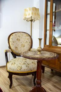 a chair with a table and a lamp in a room at Apartman Centar in Sremski Karlovci