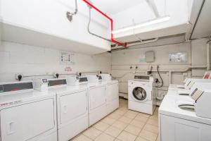 a laundry room with washing machines and a washer and dryer at Modern studio Across From Hilton lagoon beach PW920 in Honolulu