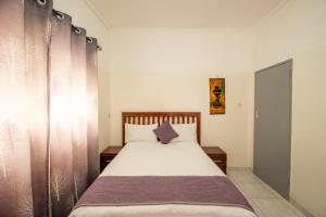 a bedroom with a bed with a wooden headboard at Wood Road Guest Lodge in Victoria Falls