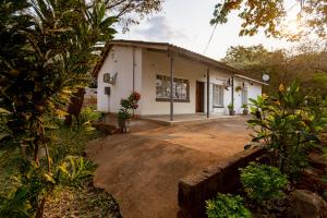 a small white house in the middle of a yard at Wood Road Guest Lodge in Victoria Falls