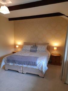 a bedroom with a large bed with two lamps at The Barn in Saltash