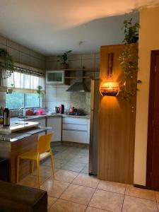 a kitchen with a table and a light on a refrigerator at Hostel Portal da Montanha in Blumenau