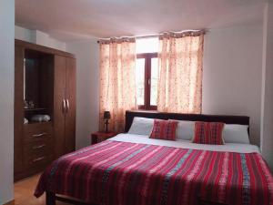 a bedroom with a large bed and a window at Chakana Family Home Lima Airport in Lima