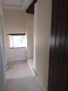 an empty room with a window and a door at The Barn in Saltash