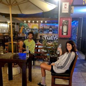 a man and a woman sitting at a table in a restaurant at Hostel THAY83 Miraflores Lima in Lima