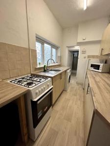 a kitchen with a stove and a sink in it at Bright Home From Home in Stoke on Trent