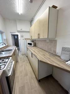a kitchen with white cabinets and a counter top at Bright Home From Home in Stoke on Trent