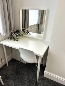 a white desk with a mirror and a white chair at Bright Home From Home in Stoke on Trent