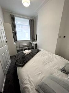 a bedroom with a large white bed with a window at Bright Home From Home in Stoke on Trent