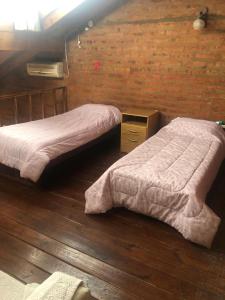 2 camas en un dormitorio con suelo de madera en Departamento en Viedma en Viedma