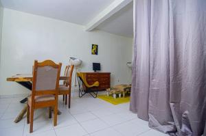 a room with a table and a chair and a desk at Diadia Apartment 1 in Dakar