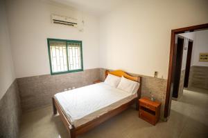 a small bedroom with a bed and a window at YUPOP APARTAMENTO in São Tomé