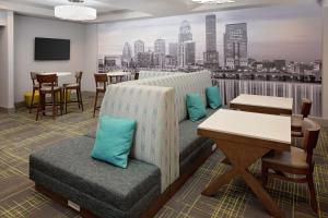 a hotel room with a couch and a table and chairs at Hampton Inn Louisville Downtown in Louisville