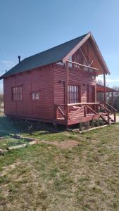 een groot houten huis met een grote veranda bij Cabañas en los reartes in Los Reartes