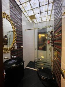 a bathroom with a black toilet and a mirror at Park Azure 463 in Baku
