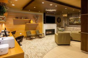 a salon with a waiting room with a fireplace at Best Western Plus Franciscan Square Inn & Suites Steubenville in Steubenville