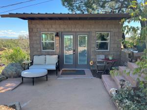 a patio with a couch and a chair and a table at NEW Feather Your Nest King bed Casita, Balcony/BBQ, Amazing views & great Location! Dog friendly in Prescott