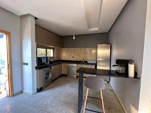 a kitchen with a table and a chair in it at Ferme Marsa in Guercif