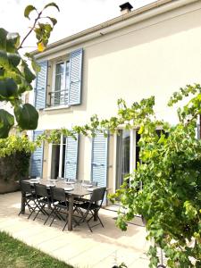 a patio with a table and chairs in front of a house at Lovely Disney House in Magny-le-Hongre