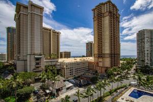 a view of a city with tall buildings and palm trees at Ocean view Balcony Walk to beach PW722 in Honolulu