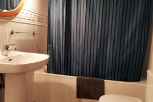 a bathroom with a sink and a shower curtain at Casa Rústica y vistas a la montaña - Els Llavadors in Villafranca del Cid +12 photos