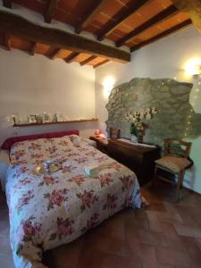 1 dormitorio con cama y pared de piedra en Stupendo monolocale per un romantico relax!, en Lama