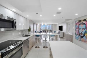 a large white kitchen with a large island in it at The Marilyn! Renovated and Amazing Skyline Views! in Miami