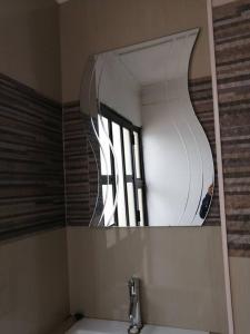 um espelho sobre um lavatório na casa de banho em Manor house em Durban