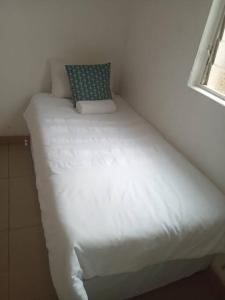 uma pequena cama num quarto com uma janela em Manor house em Durban