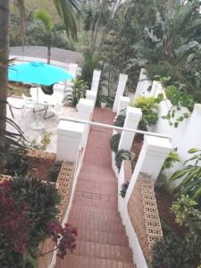 um caminho de tijolos que leva a uma piscina com uma mesa em Manor house em Durban