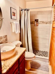 ein Bad mit einem Waschbecken, einem WC und einer Dusche in der Unterkunft A Cozy Cabin Escape in Tijeras-Hot Tub-Game room-Pet Friendly! in Tijeras