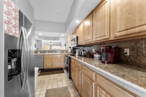 a kitchen with wooden cabinets and a stainless steel refrigerator at Green Mountain Grand Condo in Branson