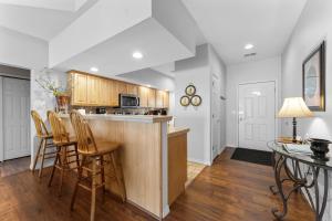 a kitchen with a bar with chairs and a table at Green Mountain Grand Condo in Branson