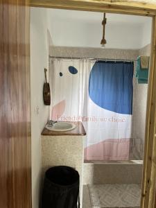 a bathroom with a sink and a window with a sign at Seacret Studios - Cozy Jamaican Retreat apts in Negril