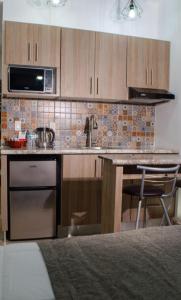 a kitchen with a counter with a sink and a stove at Hotel StayHome in Ensenada
